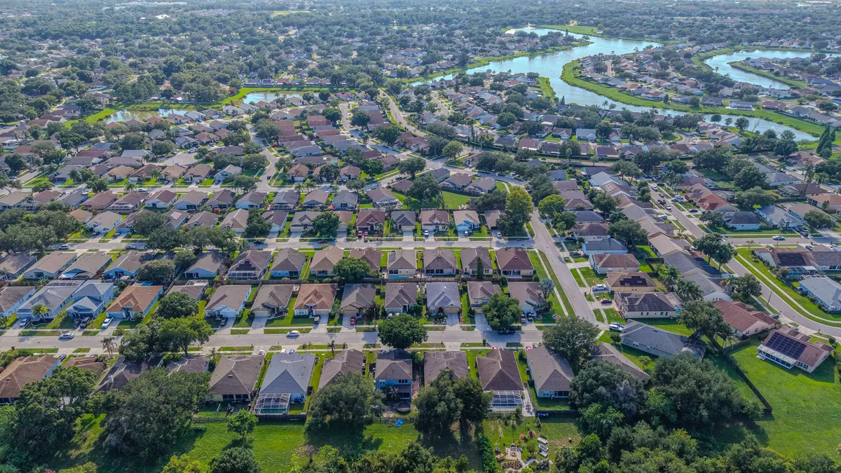 Aerial view of a single-family home neighborhood with retention ponds in Central Florida